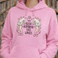 Person wearing a pink hoodie with 'My book boyfriend has wings' design in a library setting