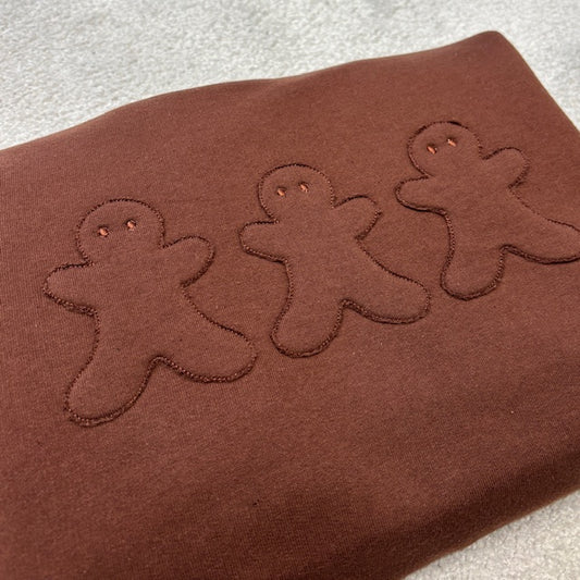 Brown fabric with appliqued embroidered gingerbread men 