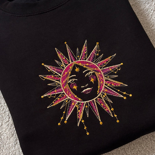 Black sweatshirt with a solar design embroidered on it.