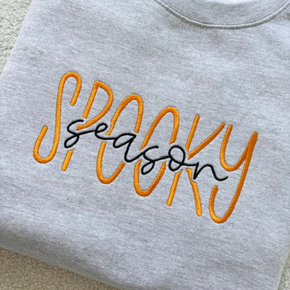 Grey sweatshirt with 'Spooky Season' text in orange and black 