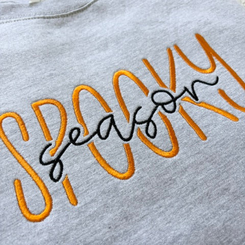 Grey sweatshirt with 'Spooky Season' text in orange and black