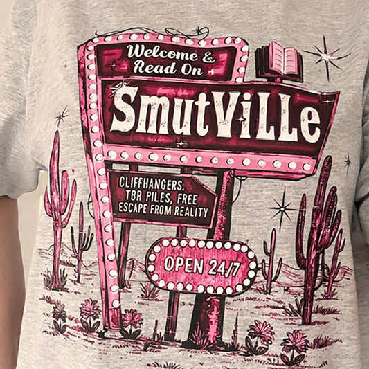 T-shirt with 'Smutville' sign design featuring cacti and desert elements.