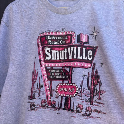 Grey t-shirt with a 'Smithville' graphic design on a wooden hanger.