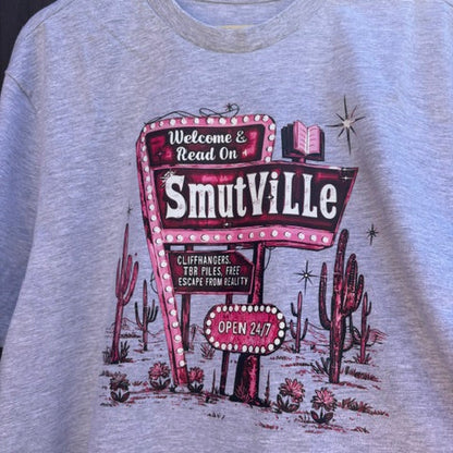 Grey t-shirt with a 'Smithville' graphic design on a wooden hanger.