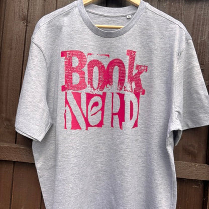 Grey sweatshirt with 'Book Nerd' in pink text on a wooden surface