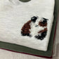 Embroidered guinea pig design on a light grey sweatshirt