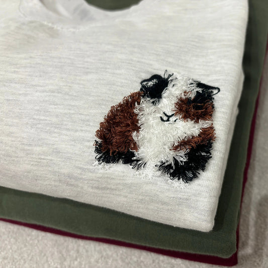 Embroidered guinea pig design on a light grey sweatshirt
