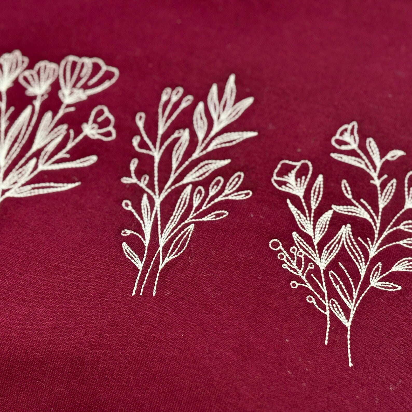White floral and leaf patterns on a red fabric background