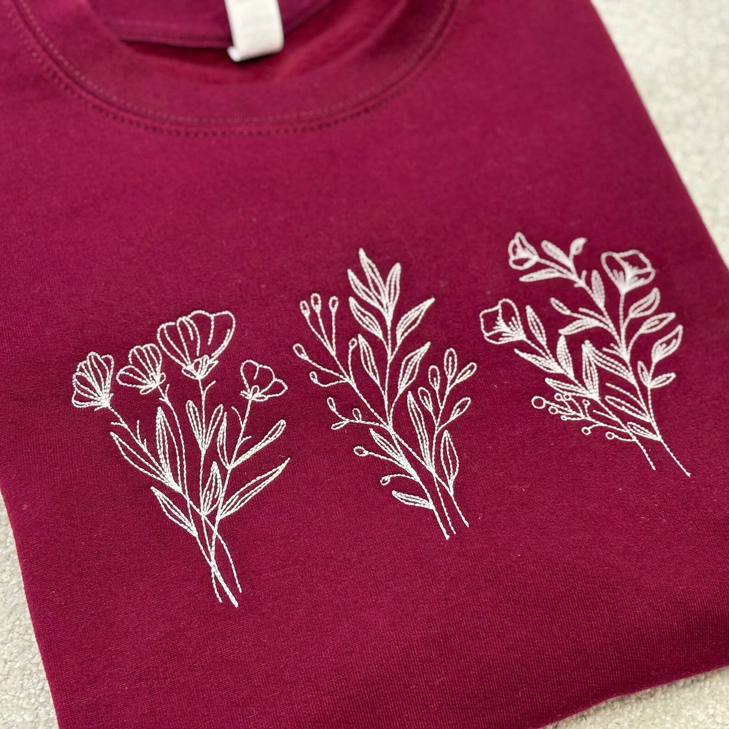 Maroon sweatshirt with white floral designs
