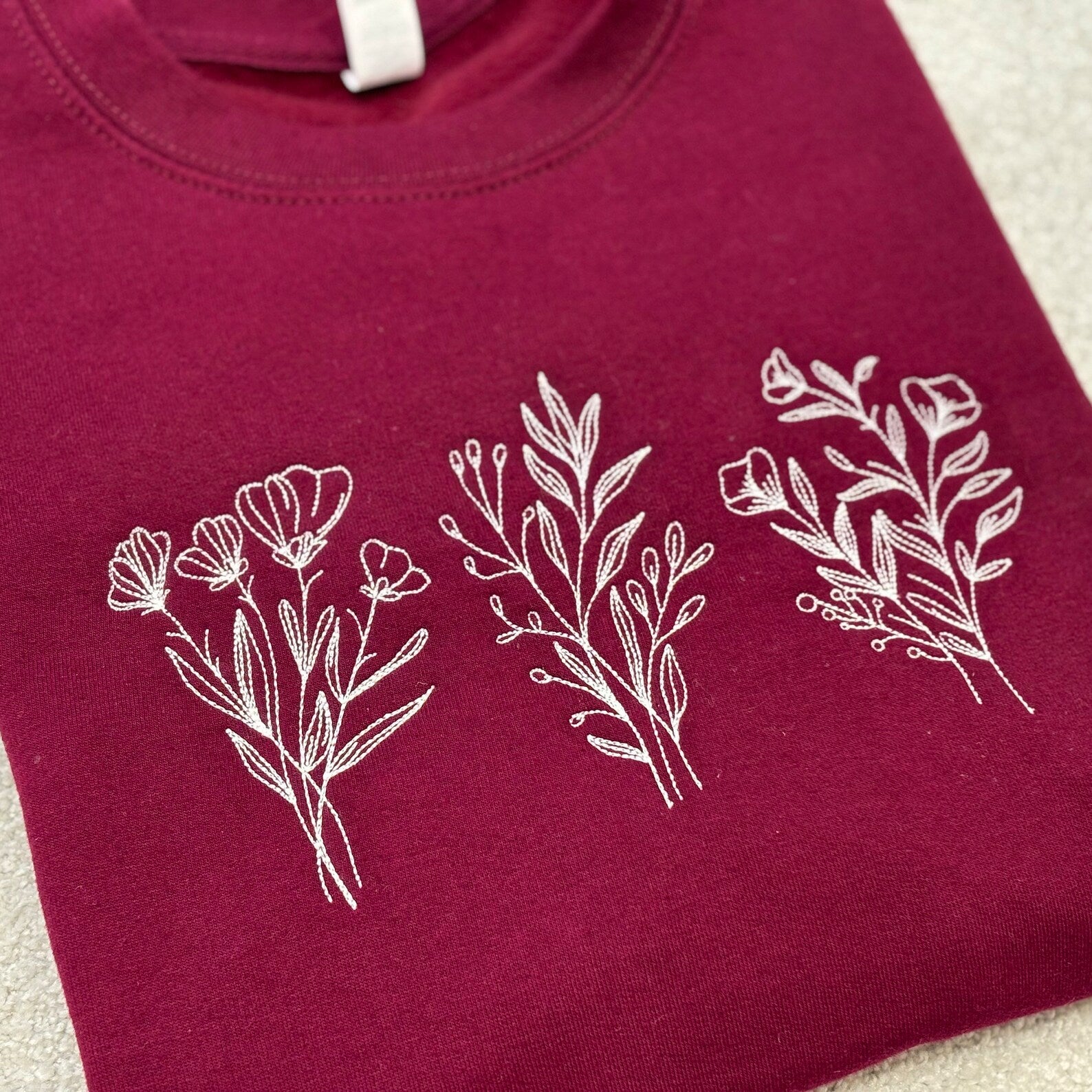 Maroon sweatshirt with white floral designs