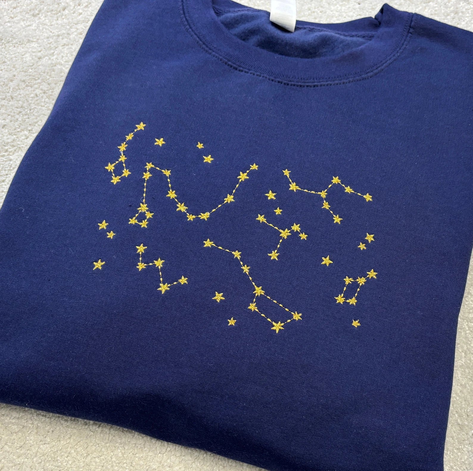 Navy blue sweatshirt with yellow star constellation design embroidery
