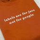 Ginger sweatshirt with white text 'labels are for jars not for people' embroidered.