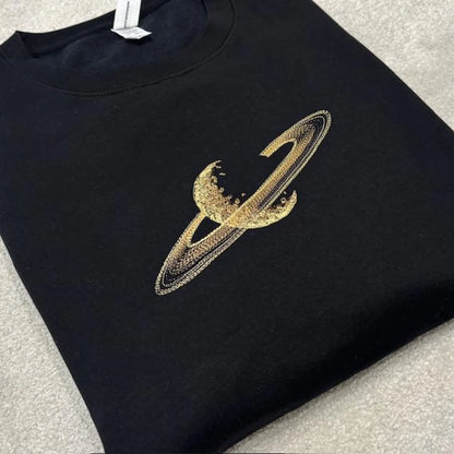 Black sweatshirt with a gold saturn rings design