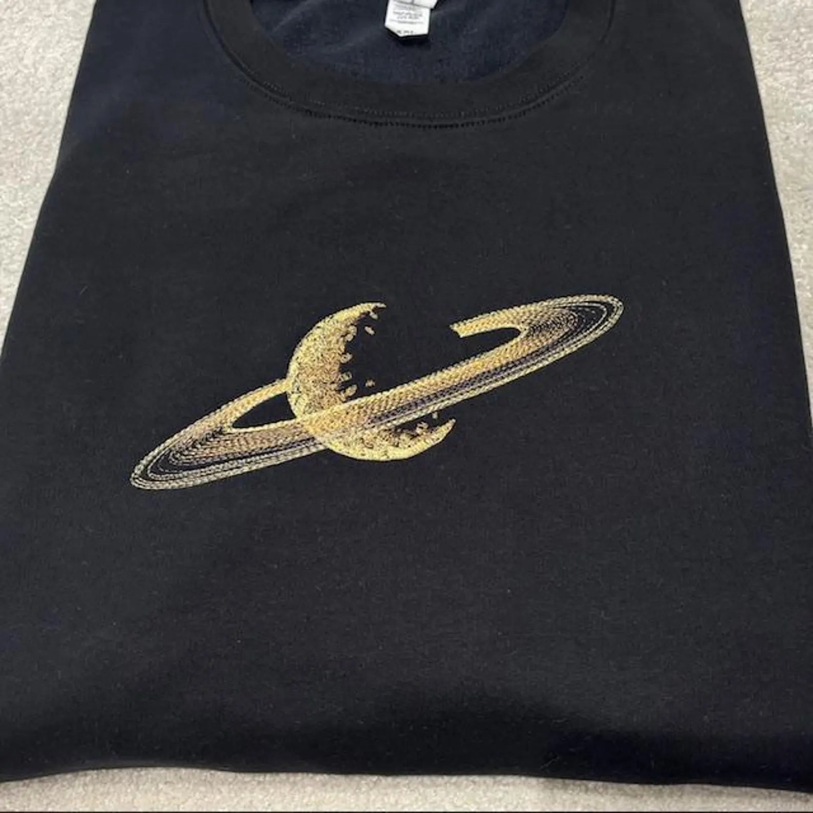 Black sweatshirt with gold Saturn design 