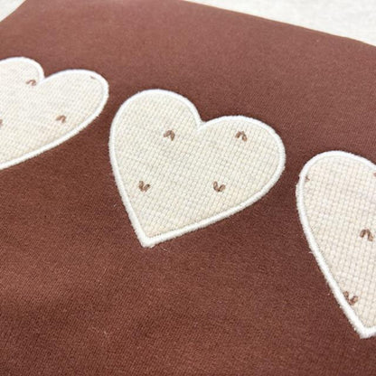Heart-shaped patches on a brown fabric background