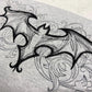 Detailed black line drawing of a gothic bat on a grey sweatshirt