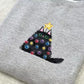 Grey sweatshirt with a black cat embroidered design featuring colourful christmas lights.