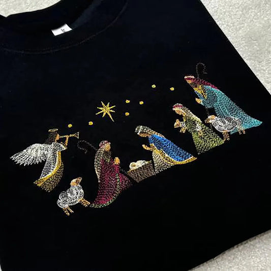 A nativity scene stitched onto a black sweatshirt. 